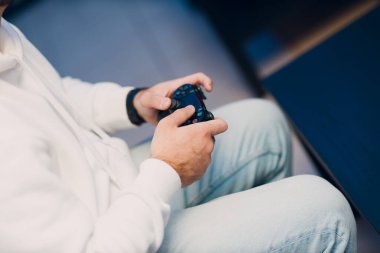 Bilgisayar oyun kulübünde oyun konsolunda oyun oynayan genç bir adam.