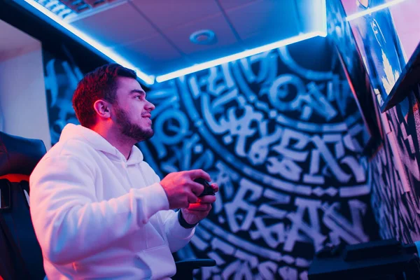 Pria muda dewasa bermain video game di konsol game di klub game komputer — Stok Foto