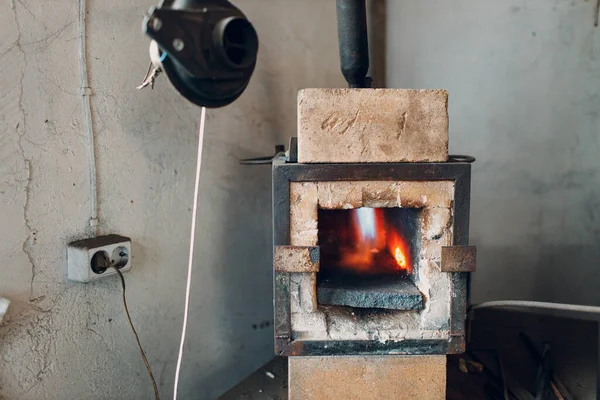 Kuźnia kuźni piekarnik z gorącym płomieniem. Smith ogrzewanie żelaza kawałek stali w ogniu kuźni czerwonej — Zdjęcie stockowe