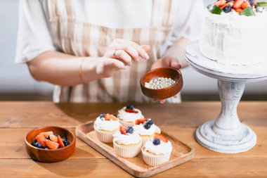 Pasta şefi, mutfak masasında pastası olan beyaz bir kadın..