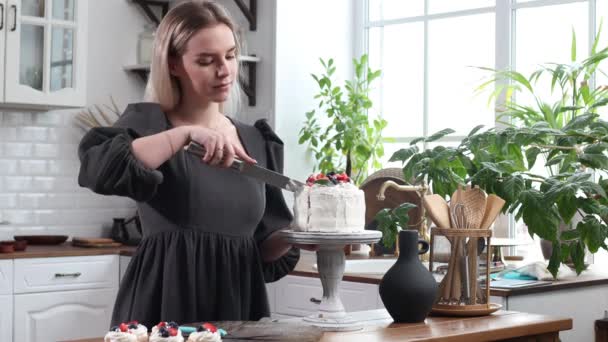Випічка шеф-кухар кондитер молода кавказька жінка з тортами на кухонному столі . — стокове відео
