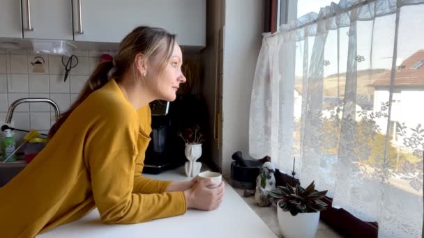 Жінка Гарячий Напій Спостерігає Вікном Вітає Когось Вулиці — стокове відео