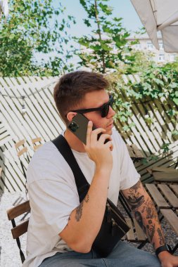 Beyaz ceketli bir adam telefonda konuşuyor.