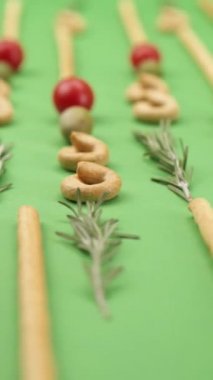 Yakın plan: İtalyan hamur işleri, İtalyan ekmeği çubukları, zeytin, kiraz domatesleri, biberiye