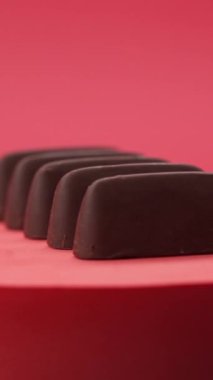 Yakın plan: Kırmızı zemin üzerinde çikolata ve şeker kompozisyonu