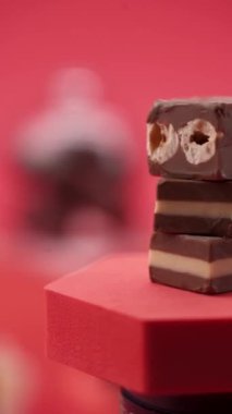 Yakın plan: Kırmızı zemin üzerinde çikolata ve şeker kompozisyonu