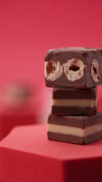 Close Samenstelling Van Chocolade Snoepjes Een Rode Achtergrond — Stockvideo