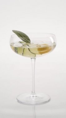 Yakın plan: Salatalık ve limonlu köpüklü şampanya kadehinde biberiye şampanyası