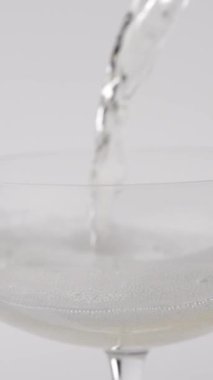 Bir bardağa doldurulan köpüklü şampanyaya yakın plan.