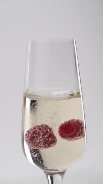 Yakın plan: Çilekler bir bardak şampanyada yüzer.