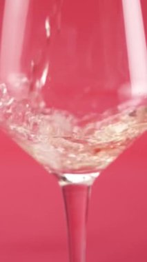 Yakın plan: kırmızı şarap bardağa dökülür.