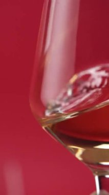 Yakın plan: kırmızı şarap bardağa dökülür.