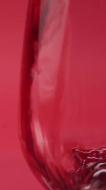 Yakın plan: kırmızı şarap bardağa dökülür.