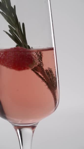 Nahaufnahme Ein Zweig Rosmarin Einem Glas Sprudelnden Champagners Mit Erdbeeren — Stockvideo