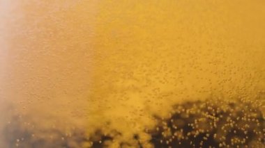 Yakın plan: Ağır çekimde bardağa köpüklü hafif bira dök
