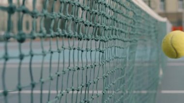 Tenis topu ağır çekimde vurulduktan sonra ağa çarptı.