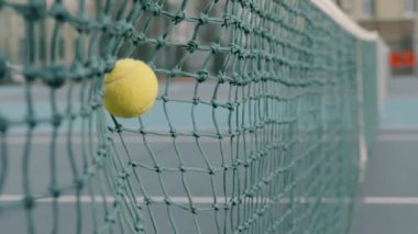 Tenis topu ağır çekimde vurulduktan sonra ağa çarptı.