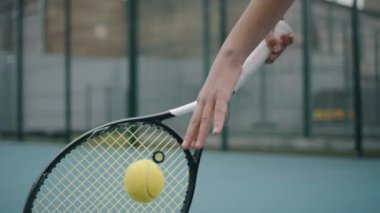 Yavaş çekimde vurmadan önce tenis topu atan bir kız.