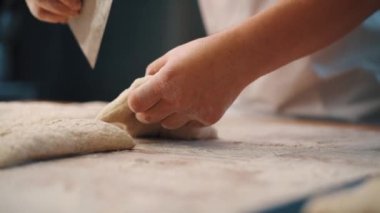 Adam mutfakta ekmek yapmak için elleriyle hamur yoğuruyor.