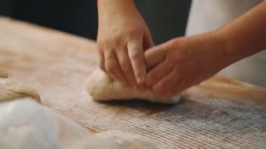 Adam mutfakta ekmek yapmak için elleriyle hamur yoğuruyor.