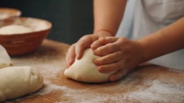 Adam mutfakta ekmek yapmak için elleriyle hamur yoğuruyor.