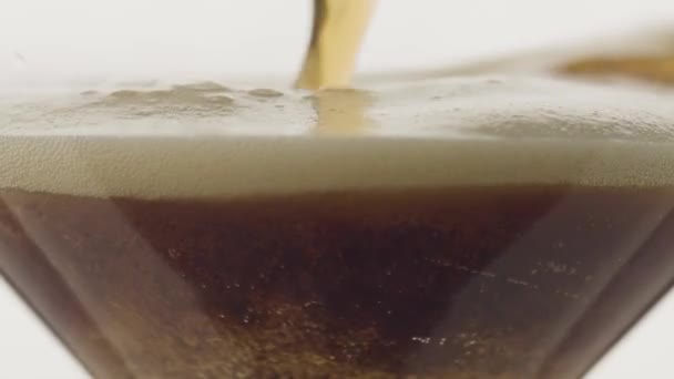 クローズアップ スローモーションでガラスの中に泡のある暗いビールを注ぐ — ストック動画