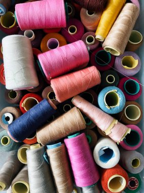 Kumaş üretimi: bir kutuda iplik makaraları, farklı renkler (üst görünüm)