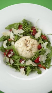 Yeşil arka planda bir tabakta salata ile Mozzarella