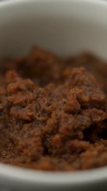 Pesto sosu, yeşil arka planda bir tabakta yakın plan.