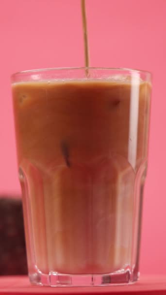Zamieszać Lodową Latte Szklance Różowym Tle — Wideo stockowe