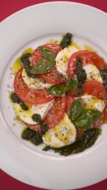 Mozzarella Med Tomat Roterar Platta Röd Bakgrund — Stockvideo