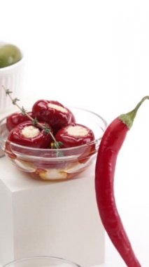 Beyaz arka planda konserve zeytin, domates, patlıcan ve biber.