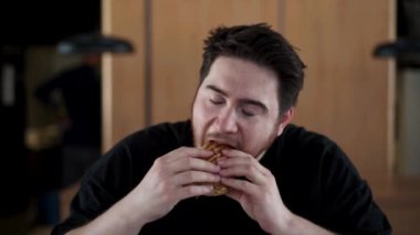 Çılgın inek zevkle lezzetli bir burger yer, sos dudaklarına akar.