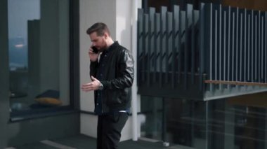 Genç sakallı adam bilişim uzmanı, telefonda pazarlık yapıyor.