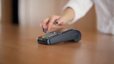 Mağazadaki terminalde NFC teknolojisi kullanılarak telefonla ödeme