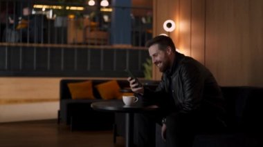 Genç sakallı adam bilişim uzmanı, telefonda pazarlık yapıyor.