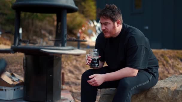 Barbeküye Yakın Bir Yerde Bir Adam Bira Içiyor — Stok video