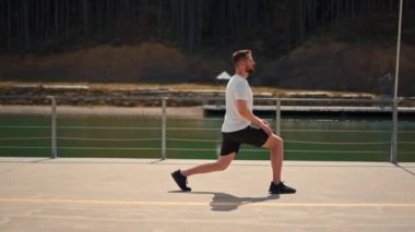 Young man athlete is engaged in exercises before running before workout challenge endurance training