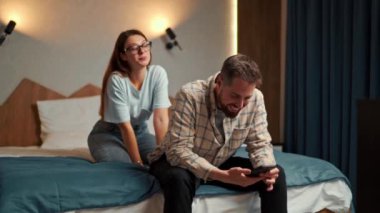 Adam otel odasındaki telefonda çalışıyor ve kız da zafer için dikkat istiyor.