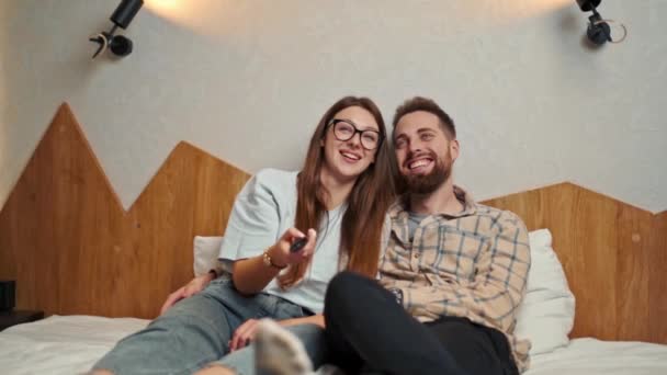一对年轻夫妇在宾馆房间看电视 面带微笑 — 图库视频影像
