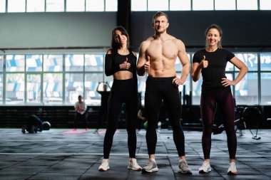 Spor salonunda spor salonunda spor yapan beyaz seksi erkek ve kadınlar ağırlık kaldırma yaşam tarzı sağlıklı yaşam egzersizleri yapıyorlar.