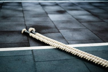 Spor salonundaki ipler kardiyo antrenmanı ve fitness ekipmanlarından sonra yerde yatıyor.