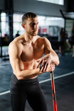 Güçlü bir adam jimnastik salonunda çekiç kullanıyor. Kaslı bir adam balyozla büyük bir lastiğe çarpıyor. Spor kulübünde yoğun antrenman yapan güçlü bir sporcu. Silüet atlet egzersizi