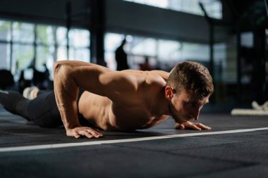 Spor salonunda şınav çeken bir adam. Şınav ve egzersizden sonra nefes alıp vermek. Spor ve spor için mükemmel. Genç sporcu spor salonunda şınav çekiyor. Sporcu spor yapıyor.