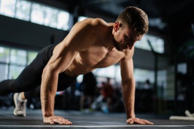 Spor salonunda şınav çeken bir adam. Şınav ve egzersizden sonra nefes alıp vermek. Spor ve spor için mükemmel. Genç sporcu spor salonunda şınav çekiyor. Sporcu spor yapıyor.