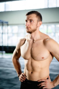 Sporcu adam spor salonunda sert poz veriyor.