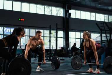 Sporcu erkek ve kadın Doe Deadlift ve ağır halterli kıvırcık halterler. Atletik Üstsüz Adam Eğitimi, Güç Kullanımı, Güç ve Dayanıklılık Halterleri. Hardcore Spor Salonu 'nda egzersiz