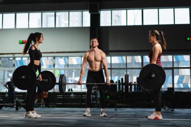 Sporcu erkek ve kadın Doe Deadlift ve ağır halterli kıvırcık halterler. Atletik Üstsüz Adam Eğitimi, Güç Kullanımı, Güç ve Dayanıklılık Halterleri. Hardcore Spor Salonu 'nda egzersiz