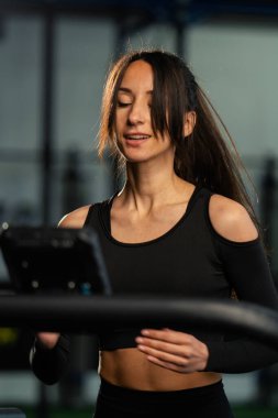 Koşu bandında koşan bayan sporcu