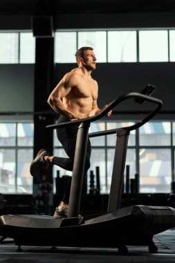 Erkek sporcu koşu bandında koşuyor.